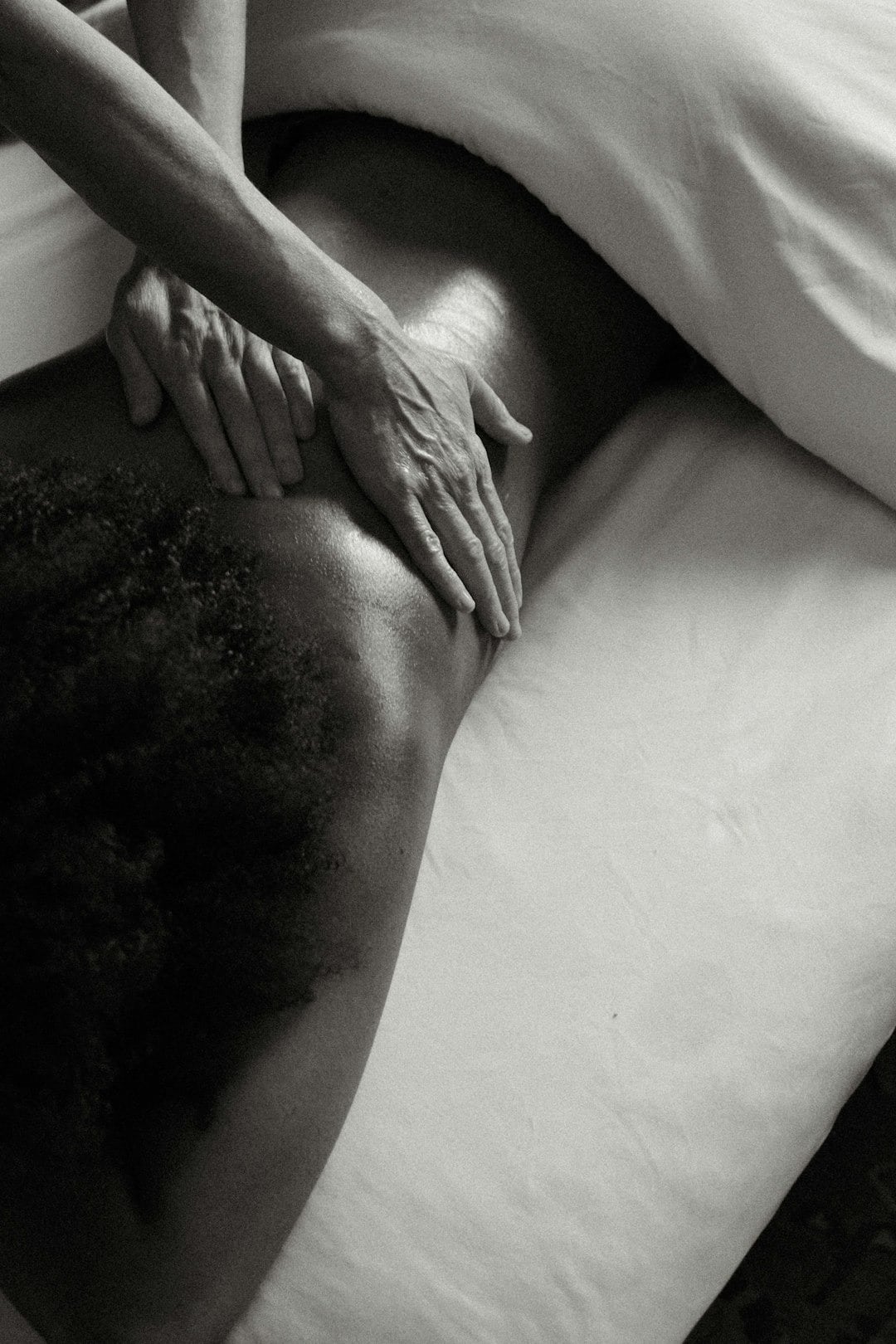Hands giving a back massage with therapeutic touch.